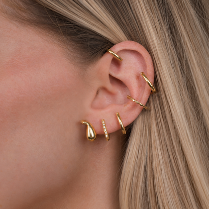 Silver ear cuff worn on ear, close-up lifestyle shot, no piercing needed